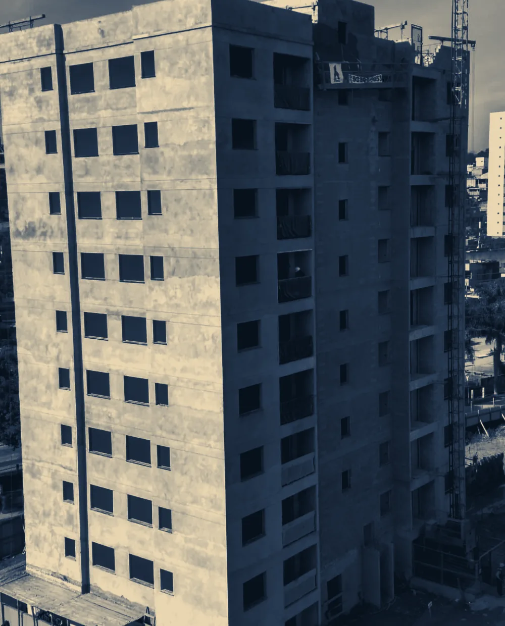 Edifício residencial de dez pavimentos em fase de estrutura de concreto e alvenaria, com grua ao fundo
